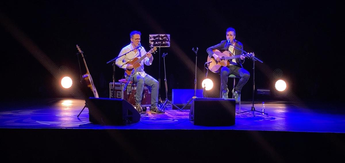 Le duo sur scène, sous les projecteurs bleus