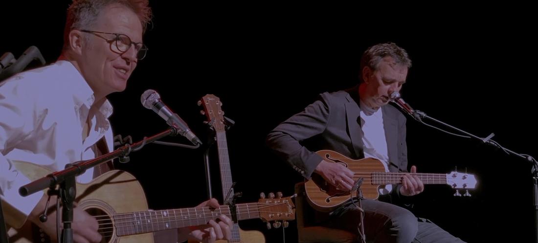 Les deux musiciens en concert, micros devant eux