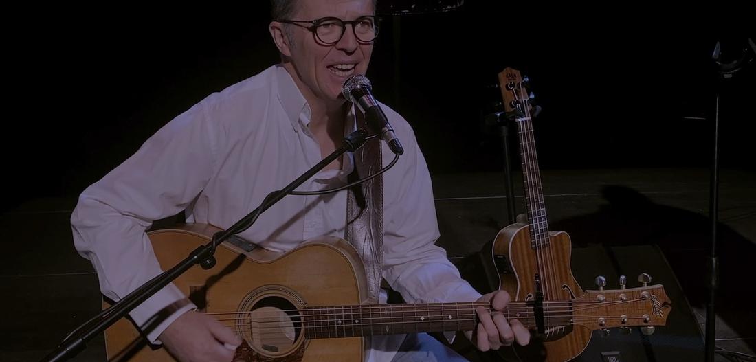 Le chanteur en chemise blanche, guitare et micro