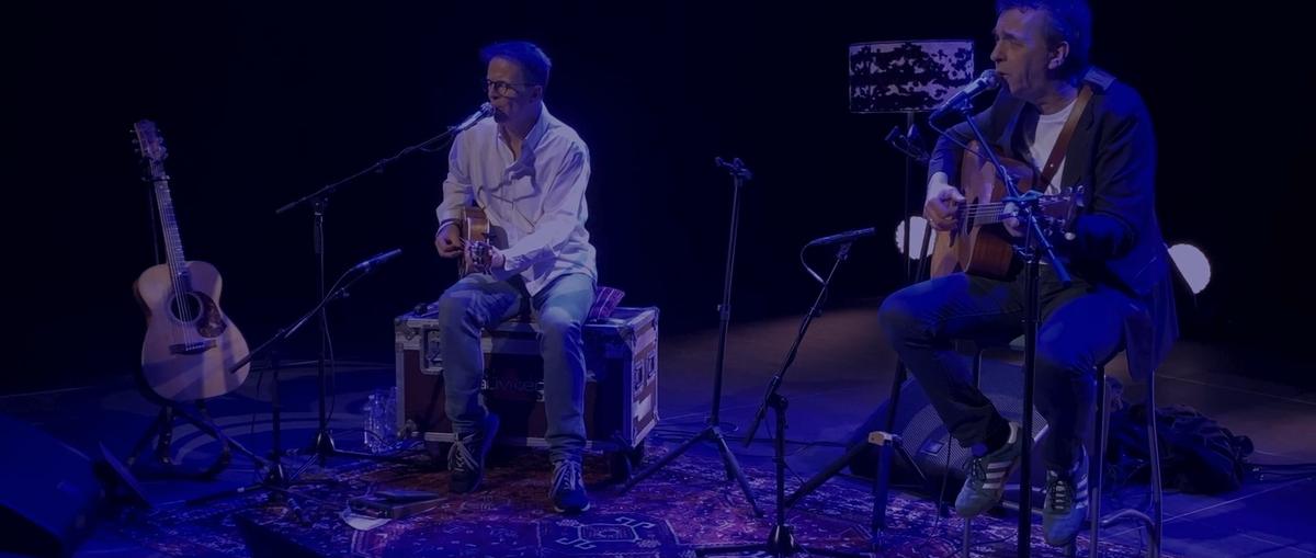 Le duo sur scène dans une lumière bleue